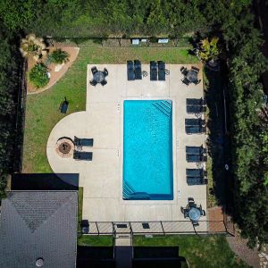 Aerial shot of Encino Park apartments showing pool and clubhouse along with green landscaping